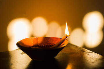 diya or earthen oil lamp lit with flame during diwali celebration in india. deepabali or kali puja...