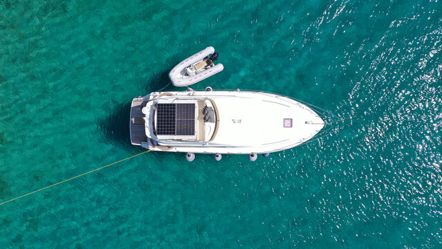 Aerial drone top view photo of small yacht - boat anchored in tropical exotic paradise bay with emerald open ocean - Powered by Adobe