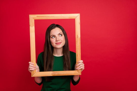 Photo of nice brunette millennial lady look empty space in frame wear green shirt isolated on red color background - Powered by Adobe