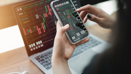 Woman sits at work using a laptop to analyze stock market. foreign exchange and banks , Plan a strategy to invest in business growth with higher statistics to reduce the risk of decision making.