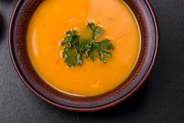Delicious hot pumpkin and carrot soup puree with spices and herbs