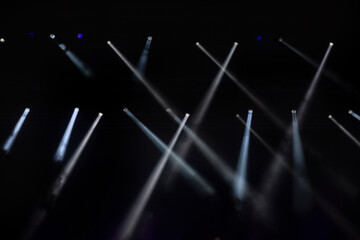 Fototapeta premium Stage lighting. Spotlights with colored lights on a stage. Artificial lighting. Black background and blur.