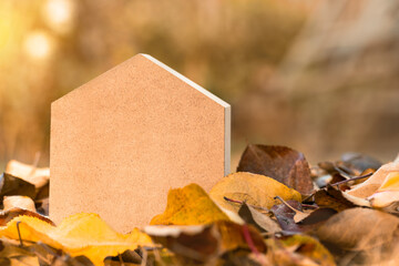 Toy Wooden house in autumn on autumn leaves, copy space. The concept of buying a new home, mortgage, renting