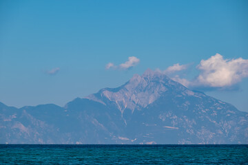 Panoramic early morning view of cloud covered holy Mount Athos from Fava sand beach, Vourvourou,...