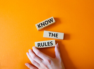 Know the rules symbol. Wooden blocks with words Know the rules. Beautiful orange background. Businessman hand. Business and Know the rules concept. Copy space. - obrazy, fototapety, plakaty