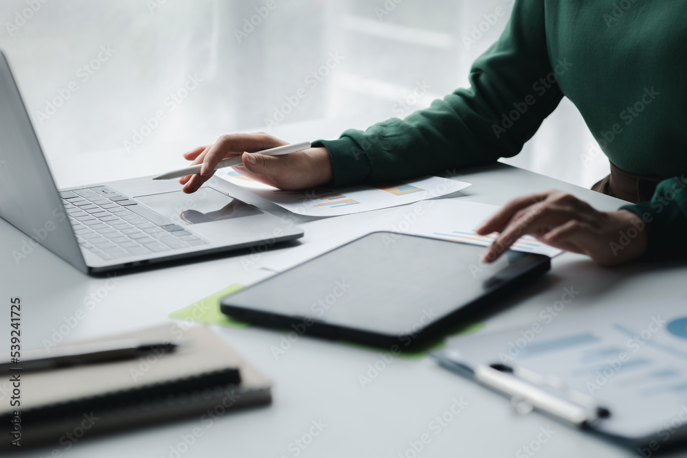 Wall mural Business men are looking at the company's financial documents on tablets to analyze problems and find solutions before bringing the information to a meeting with a partner. Financial concept.