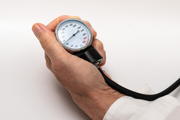 The doctor's hand holds a manometer from a device for measuring blood pressure.