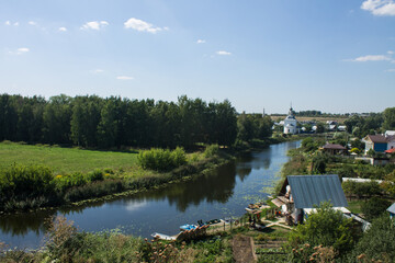 Obraz premium Tourists are rafting on the winding Kamenka river in Suzdal Russia among meadows with grass on a sunny summer bright day and a space for copy