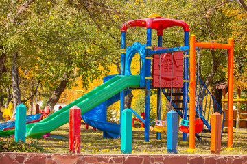 Bright playground in the park. Playground with slides and swings for children.