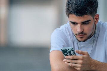 young man on the street looking at the phone or smartphone