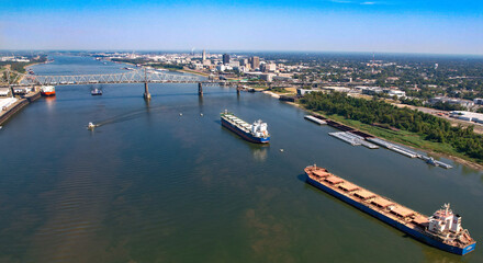 Baton Rouge Louisiana Mississippi River Bridge cargo ships tug boats levee state captiol in city high shot afternoon