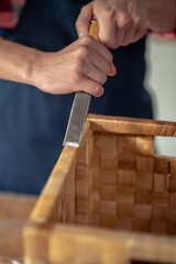 Woodworker running the chisel across the straw box edge