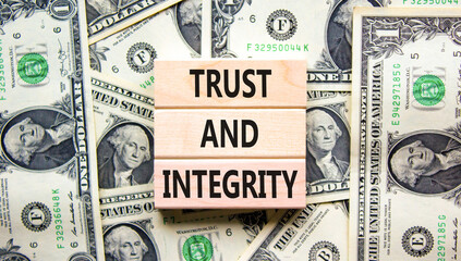 Trust and integrity symbol. Concept words Trust and integrity on wooden blocks. Dollar bills. Beautiful background from dollar bills. Business, psychological trust and integrity concept. Copy space.