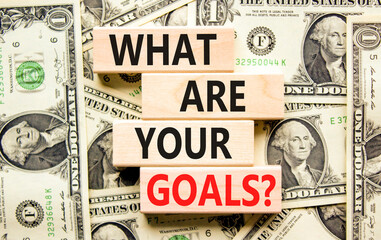 Naklejka na ściany i meble What are your goals symbol. Concept words What are your goals on wooden blocks. Beautiful background from dollar bills. Business, psychological what are your goals concept. Copy space.