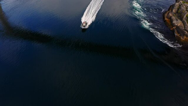 Aerial view of a boats driving through the Saltstraumen maelstrom in Norway pan, drone shot