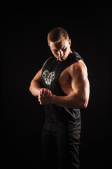 Fototapeta na wymiar portrait of an athlete who shows his muscles on a black background