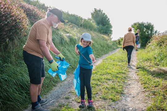Volunteers picking garbage from ground in countryside
