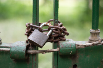 candado oxidado que cierra una antigua reja verde