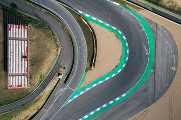 Aerial top down drone view of a racing track with tight turns and hairpins