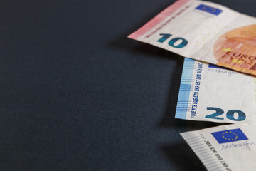 Black background with euro banknotes on the edge of the image