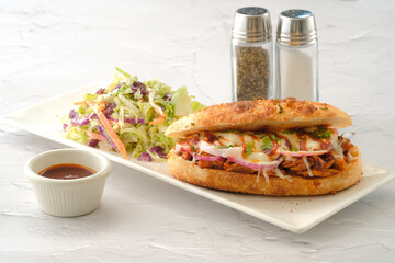 The Original BBQ Pulled Pork Sandwich with salad and chilli sauce served in a dish isolated on background side view of fastfood