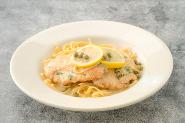Specialty Chicken Piccata with lemon slice served in a dish isolated on background side view of fastfood
