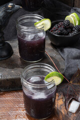 The raven mixed cocktail vertical view in wide mouth jars.