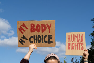 Protesters holding signs with slogans My Body My Choice and Human rights. People with placards supporting abortion at protest rally demonstration.