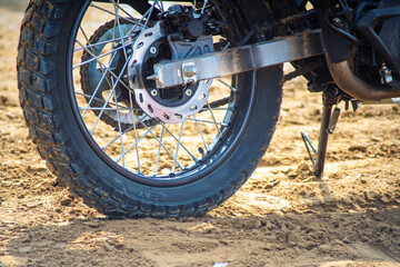 shot of rear ribbed off road wheel of dirt bike at the start line of race throwing mud as it moves showcasing the bikes and protective grear in this popular hobby