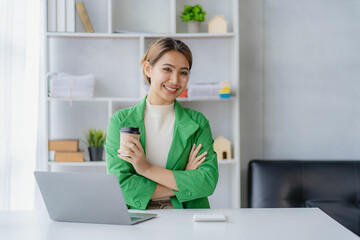 Fototapeta na wymiar Independent Asian woman working from home Business woman using laptop sitting on a desk in home office, lifestyle concept, woman working online on the internet.