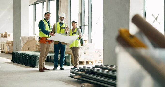 Building, construction and architect with a team working on site while reading a blueprint or plans indoors. Teamwork, engineer and architecture with a man and woman contractor group in collaboration