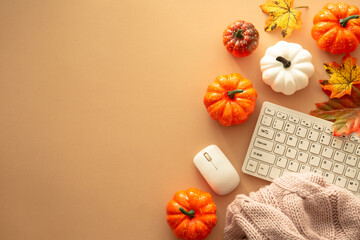 Autumn office workspace. Keyboard, laptop, notebok with autumn clothes and fall decorations -...