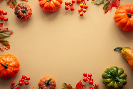 Autumn flat lay background with copy space at color paper. Pumpkins, leaves and decorations.