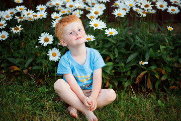 Kyiv, Ukraine - August 18, 2022. Portrait of a 3-year-old boy with red hair and blue eyes