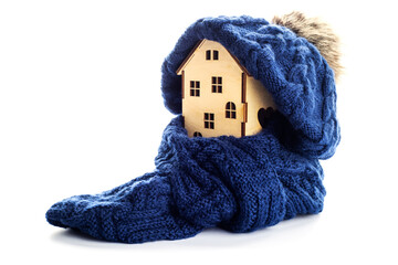 Wooden toy house with warm hat and scarf isolated on white background
