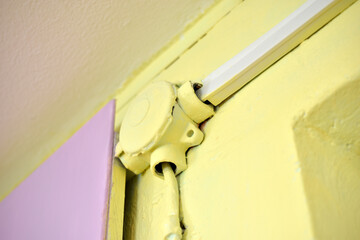 Mounting the electric cable on the wall in protection on a colored wall. Electrical wires are protected indoors.