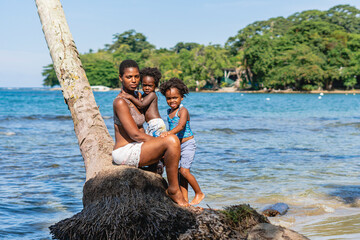 Imagen de una hermosa familia afro americana sobre una palmera viendo a cámara disfrutando de un...