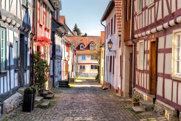 Fototapeta na wymiar Gepflasterte Straße mit sanierten Fachwerkhäusern am Rand im historischen Stadtkern von Idstein im Taunus, Hessen, Deutschland
