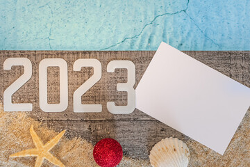 Concept de bonne année 2023 avec un coquillage et une étoile de mer au bord d'une piscine....