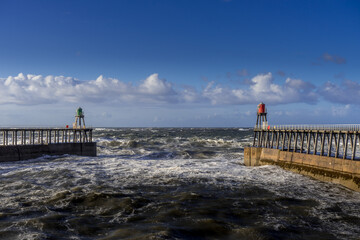 Fototapeta premium Looking out to sea from Whitby, North Yorkshire. The west and east piers frame the photo.
