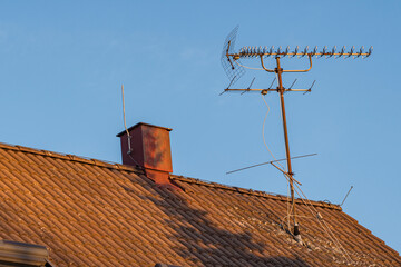 Analogue antenna with chimney on the roof of a house