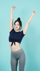 Fitness sportswear woman smile and pose body exercise at camera isolated on blue green background. Perfect body sporty woman relaxing after training. Fit and firm people. Sport Health and wellness.