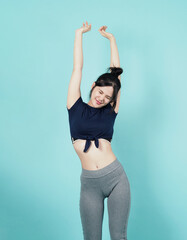 Fitness sportswear woman smile and pose body exercise at camera isolated on blue green background. Perfect body sporty woman relaxing after training. Fit and firm people. Sport Health and wellness.