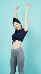 Fitness sportswear woman smile and pose body exercise at camera isolated on blue green background. Perfect body sporty woman relaxing after training. Fit and firm people. Sport Health and wellness.