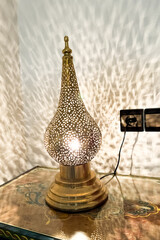 Metal Arab lamp sitting on the bedside table