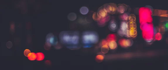 Foto op Canvas Soft blurred bokeh light background in vibrant colors on the city street at night © Naya Na