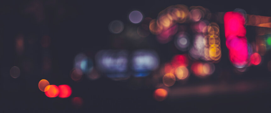 Soft blurred bokeh light background in vibrant colors on the city street at night