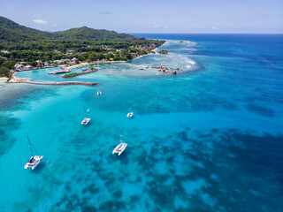 Aerial drone of luxury yachts anchored in tropical exotic island with crystal clear turquoise sea...