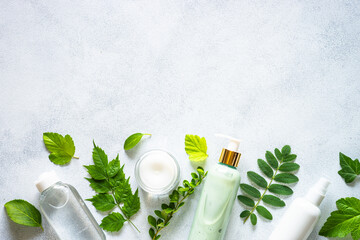 Natural cosmetics. Skin care product, cream, soap, mask with green leaves. Flat lay image on white...