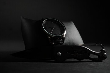 Closeup shot of a men's elegant wristwatch and pocket knife - obrazy, fototapety, plakaty